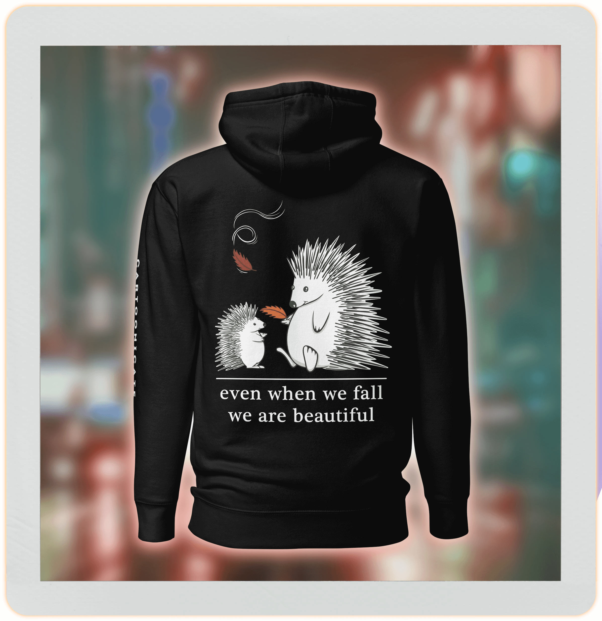 two cute hedgehogs in autumn leaves on black hoodie