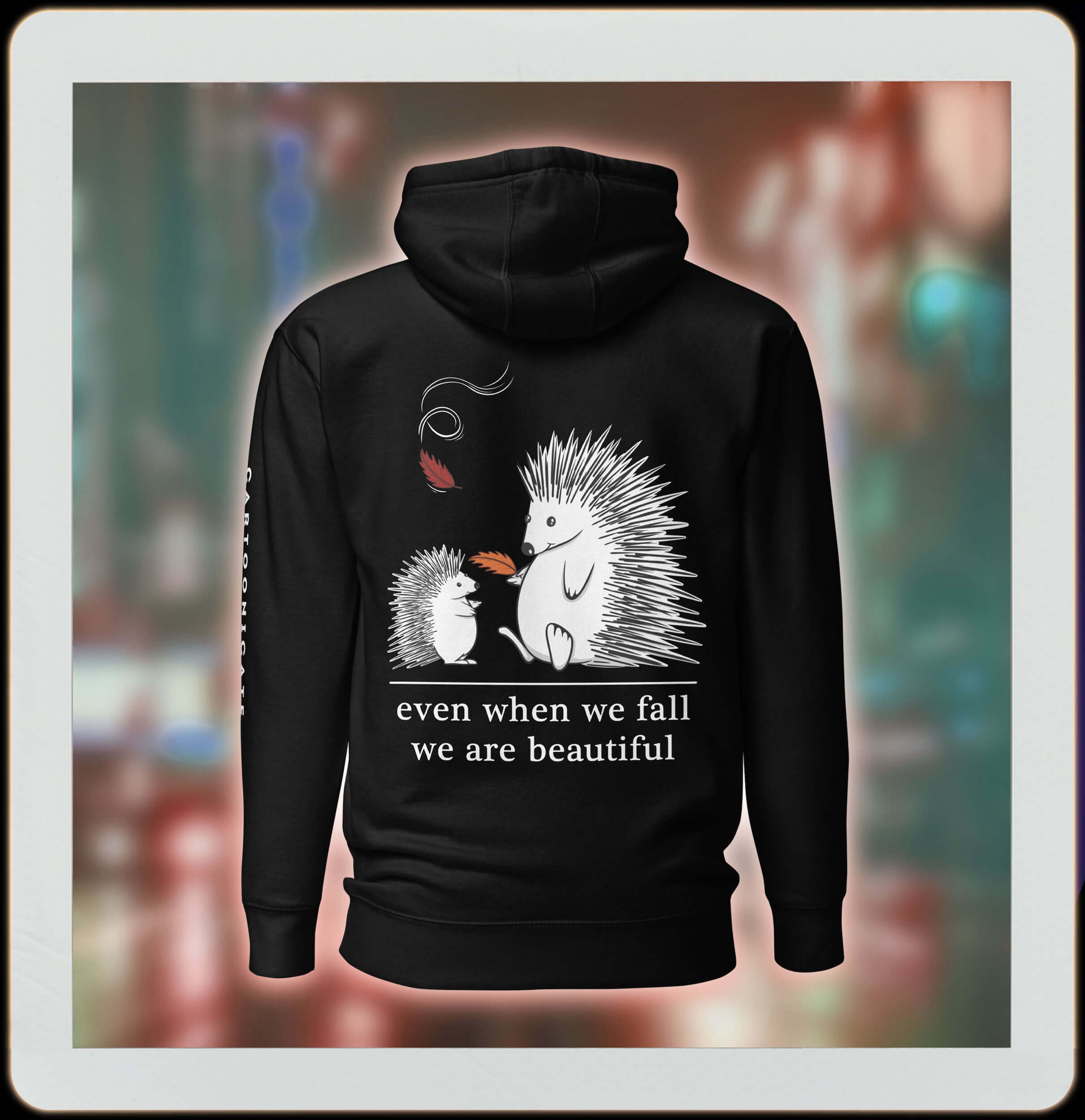 two cute hedgehogs in autumn leaves on black hoodie